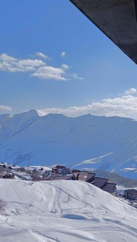 a view of a snow covered mountain with houses and buildings at Gudauri Roshka Studio Apt #412 in Gudauri