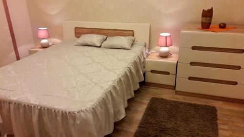a bedroom with a bed with two night stands and two lamps at Apartment Dedinje Hill 2 in Belgrade