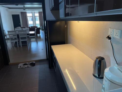 a kitchen with a counter and a dining room at VillaParadise Homestay in Batu Pahat