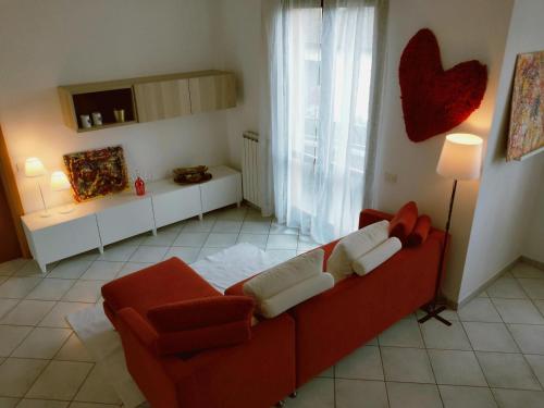sala de estar con sofá rojo y mesa en La casa del cuore - Luxury Apartment, en Olgiate Comasco