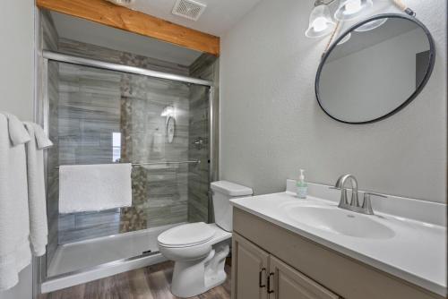 La salle de bains est pourvue de toilettes, d'un lavabo et d'un miroir. dans l'établissement Above It All Getaway, à Branson West