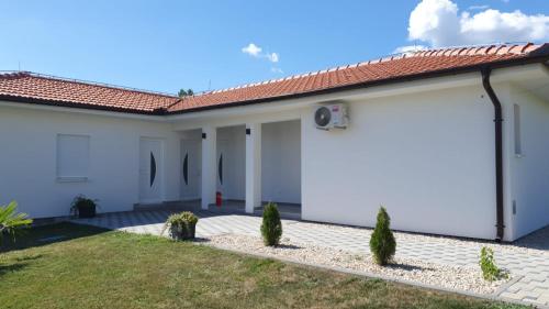 a house with white walls and a red roof at Apartment Kravica in Ljubuški