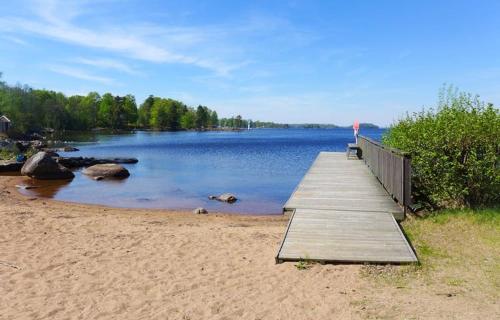 a wooden dock on a beach next to a lake at Attefallshus säng 160 bäddsoffa 160 in Växjö