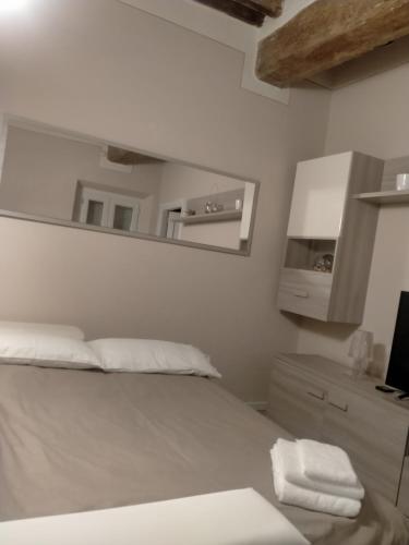 a white bedroom with a bed and a mirror at Casa Toscanella in Pescia