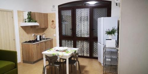 uma cozinha com uma mesa branca e um frigorífico em Al Civico 365 em Castelluzzo