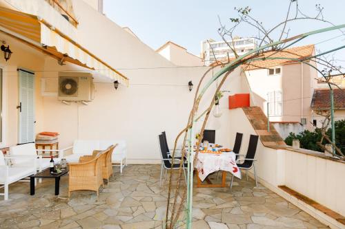 un patio avec une table et des chaises dans un bâtiment dans l'établissement Little Garden YourHostHelper, à Cannes