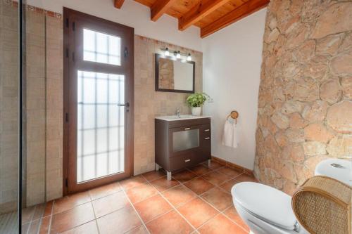 ein Bad mit einem Waschbecken und einen TV in einem Zimmer in der Unterkunft Can March magic sunset in Ses Paisses