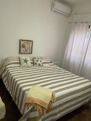 a bedroom with a large bed with a striped blanket at Soya Departamentos PB A in Junín