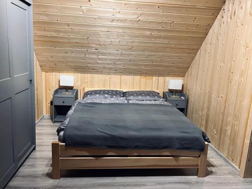 um quarto com uma cama grande e 2 mesas de cabeceira em Domki w Borach em Wycinki