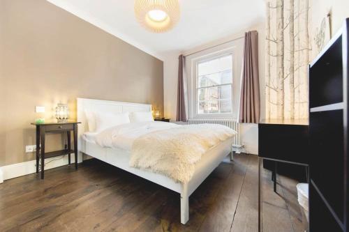 1 dormitorio con cama blanca y ventana en Franks Pied-à-terre in London-Quiet,Bright,Central, en Londres