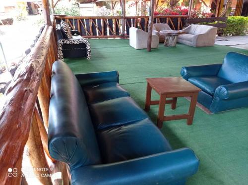 a porch with a couch and chairs and a table at Alojamiento Rural Altos del Molino in Los Andes
