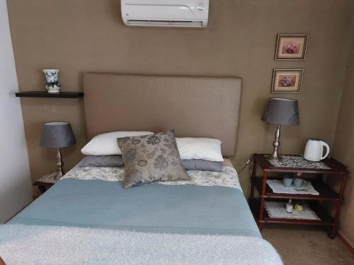 a bedroom with a bed and two night stands with lamps at Anna Katarina in Sabie