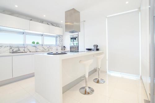 a kitchen with white cabinets and a white counter top at Villa Indigo in Protaras