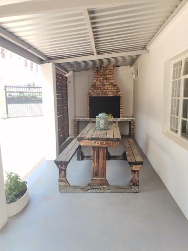 a picnic table on a patio with a fireplace at Hartland Gastehuis/Guesthouse in Vredendal