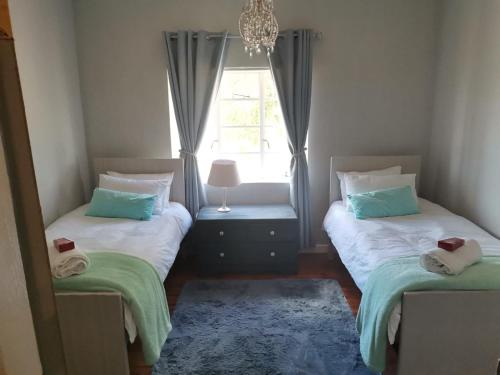 En eller flere senge i et værelse på Hartland Gastehuis/Guesthouse