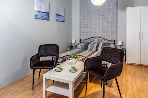 1 Schlafzimmer mit einem Bett, 2 Stühlen und einem Tisch in der Unterkunft Ośrodek Wypoczynkowy Relaks i Apartamenty in Łeba