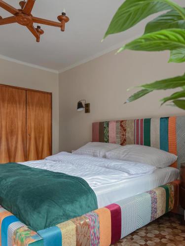 a bedroom with a bed with a colorful blanket on it at Apartament Antresola Stary Rynek in Zielona Góra