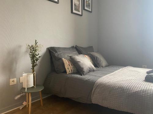 a bedroom with a bed and a table with a plant at Le Petit Curiste Metz Luxembourg Un-Séjour-à-Part in Rombas
