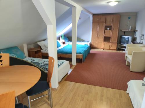 1 dormitorio con 2 camas, mesa y sillas en Holiday Vendégház, en Eger