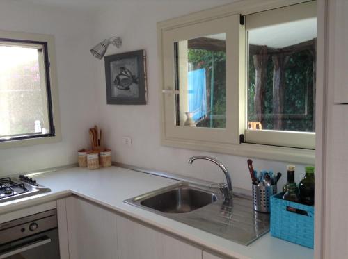 cocina con fregadero y ventana en Deliziosa Villa 150 metri dal mare, en Quartu SantʼElena