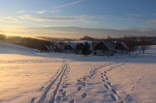 a snow covered field with footprints in the snow at Chata Větrník u Černého dolu v Krkonoších in Lauterwasser