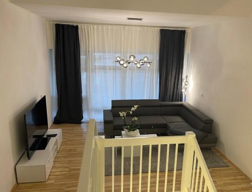 a living room with a couch and a television at Ferienwohnung an der Therme, Bademantelgang zur Limestherme in Bad Gögging