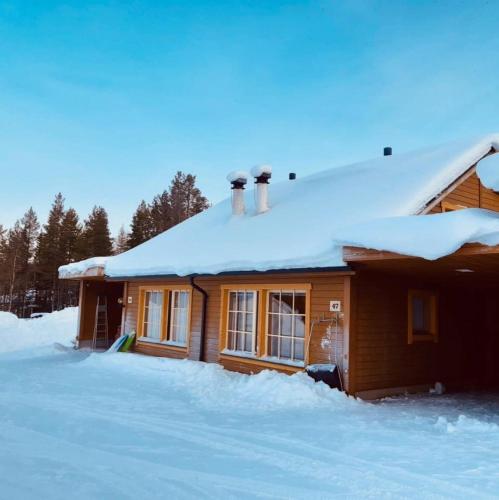 a wooden house with snow on the roof at Villa Armas 47 in Äkäslompolo
