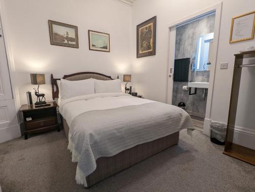 a bedroom with a large bed and a window at Cambeth Lodge Guesthouse in Inverness