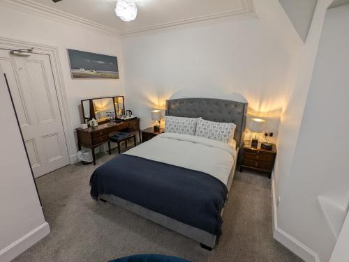 a bedroom with a bed and a desk and a bed sidx sidx sidx at Cambeth Lodge in Inverness