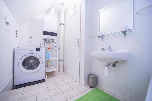 a bathroom with a washing machine and a sink at Chata Větrník u Černého dolu v Krkonoších in Lauterwasser