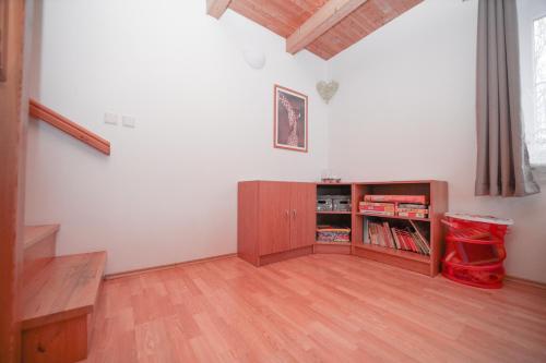 a living room with a book shelf and a staircase at Chata Větrník u Černého dolu v Krkonoších in Lauterwasser
