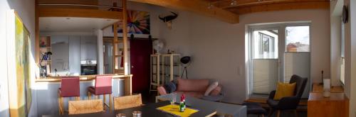 ein Wohnzimmer mit Tisch und Stühlen und eine Küche in der Unterkunft a.SIEBEN in Wittmund
