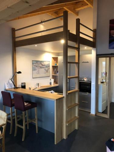 a loft bed in a room with a kitchen and a bar at a.SIEBEN in Wittmund