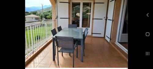 een eettafel met stoelen op een balkon bij 130m2 qui surplombe la baie de Calvi vue citadelle in Calvi