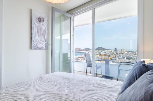 a bedroom with a bed and a view of the city at Brand New Apartment with Ocean & Volcano Views in Las Palmas de Gran Canaria