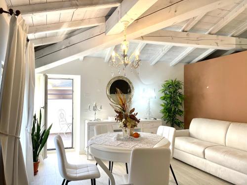 un soggiorno con tavolo e divano di Dimora di Charme Rooms & Apartments a Peschiera del Garda