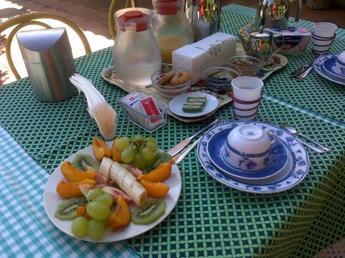 a green table with a plate of fruit on it at B&B Tramonto d'Oro in Castel del Monte