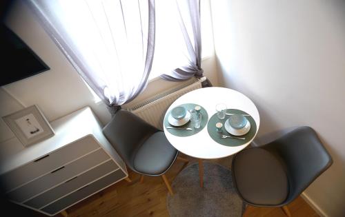 einen Tisch und zwei Stühle in einem Zimmer mit Fenster in der Unterkunft Mad In Vienna in Wien