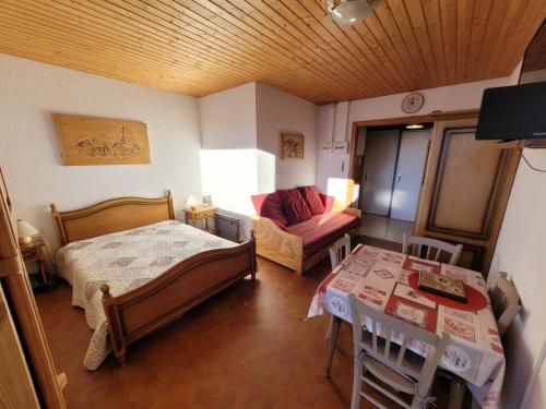 a room with a bed and a couch and a table at studio le panorama in La Bresse