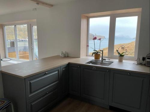 a kitchen with a sink and a large window at The house with the amazing view in Sørvágur