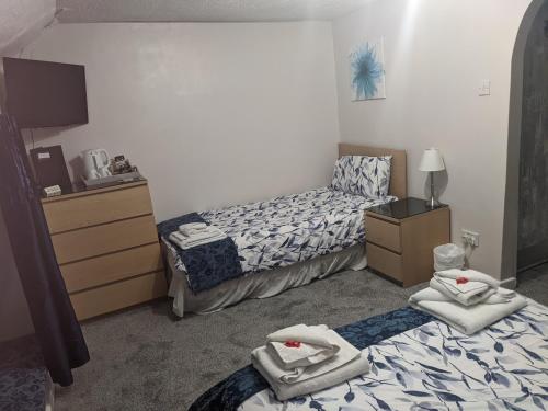a bedroom with two beds with towels on them at Cwmbach Guest House in Neath