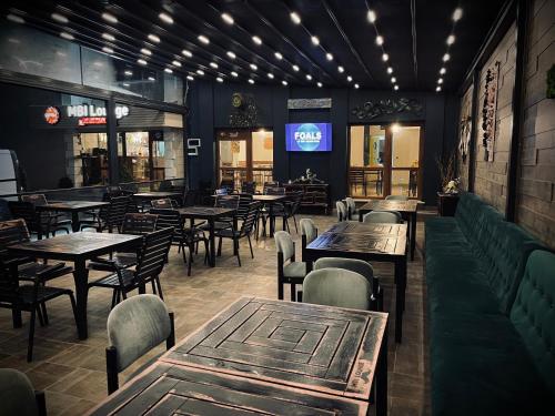 a restaurant with tables and chairs and a tv at MBI Travel Inn in Craiova