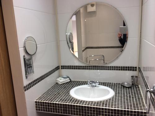 a bathroom with a sink and a mirror at Cwmbach Guest House in Neath