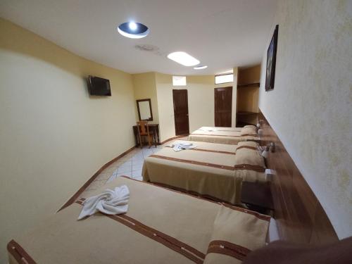 a group of four beds in a room at Hotel Nakbé Atitlán in Panajachel