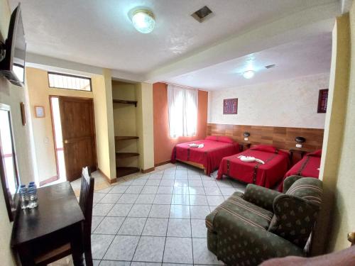 a waiting room with red beds and a couch at Hotel Nakbé Atitlán in Panajachel