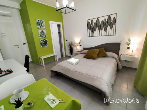 a bedroom with a large bed and a green wall at B&B Giovaldi's Torino in Turin