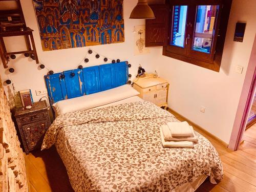 グラナダにあるLa Casa Rota de Granadaのベッドルーム1室(青いヘッドボード付きのベッド1台付)