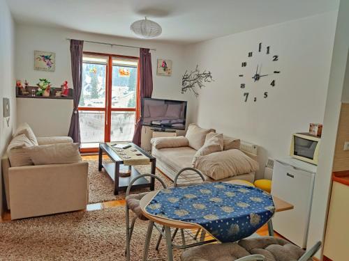 un soggiorno con divano e tavolo di APARTMAN SNOW Vlašić a Vlasic