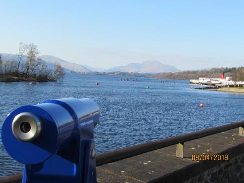 a blue camera on a railing near a body of water at Levenside Holiday Apartment, Balloch, Loch Lomond in Balloch