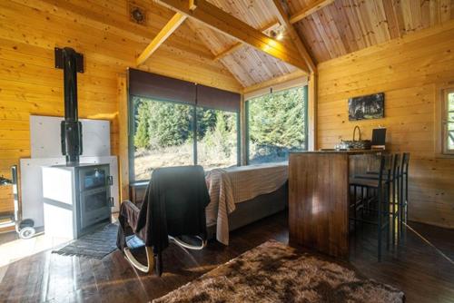 Wood Cabin by the River - for Nature Lovers في فيتينا: غرفة نوم بسرير ومكتب في كابينة